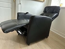 Fin brugt elektrisk lænestol i sort læder